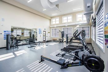 A gym with a treadmill in the foreground.